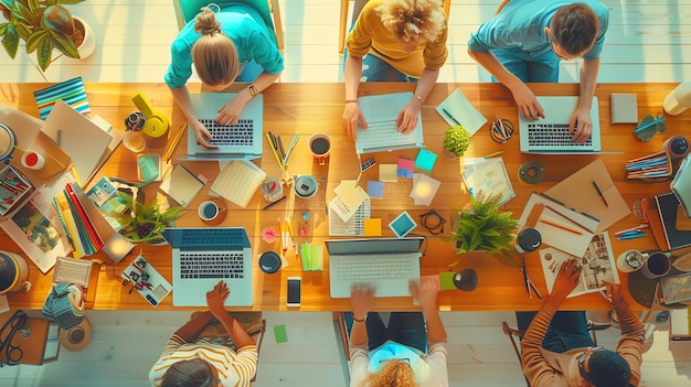 Top view of a group of young professionals working together at a wooden table