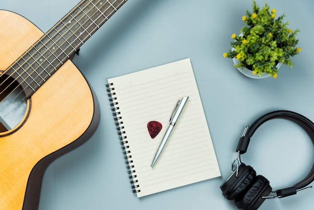 Top view guitar and note book and headphone, music concept