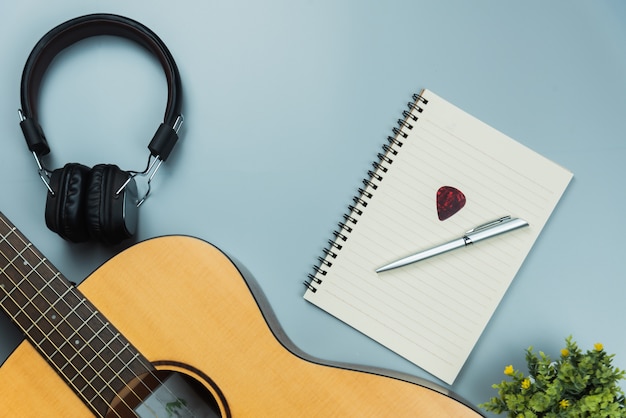 Top view guitar and note book and headphone, music concept