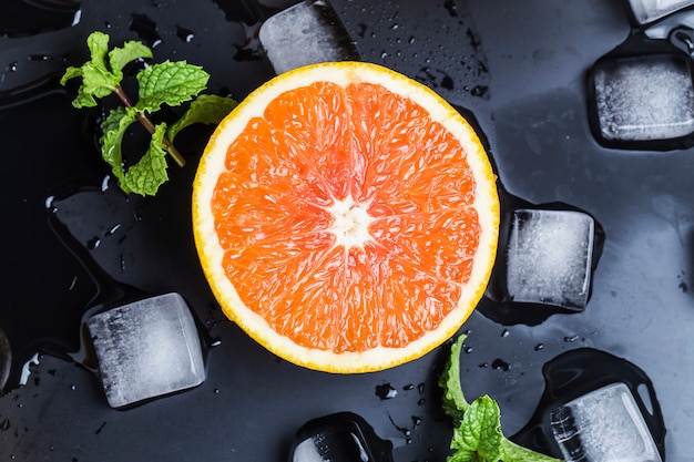 Top view of half orange with ice and mint