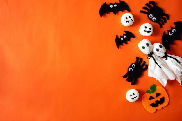 Top view of Halloween crafts on orange background with copy space for text.