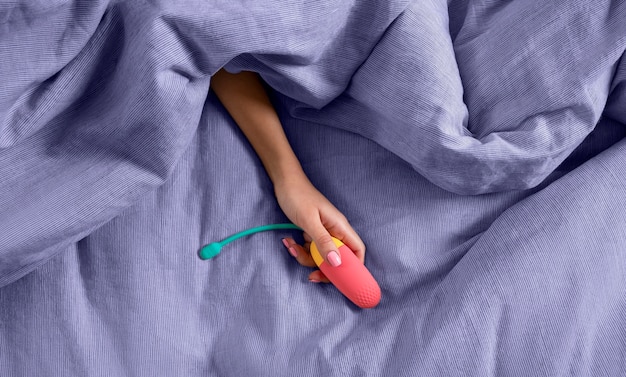 Photo top view hand holding colorful vibrator