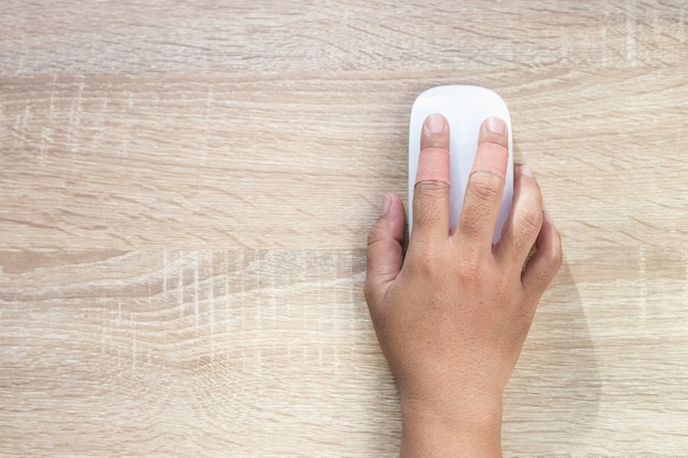 Top view hand with injury on finger using white computer wireless mouse