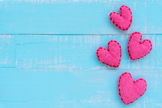 Top view of handmade pink heart on blue and white color wooden background