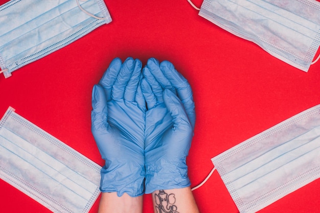 Top view of hands of doctor near medical masks on red background