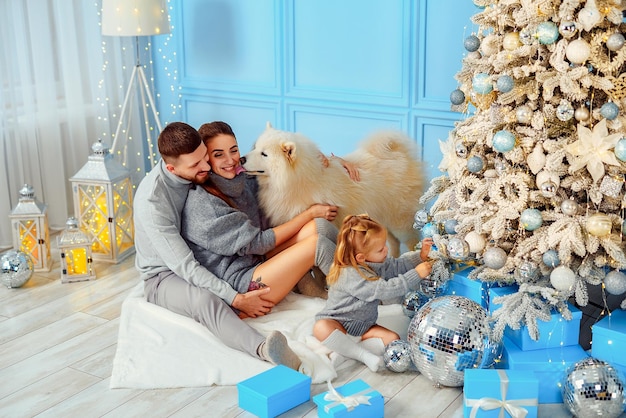 Top view of happy family mom dad daughter and dog which spend time together near Christmas tree