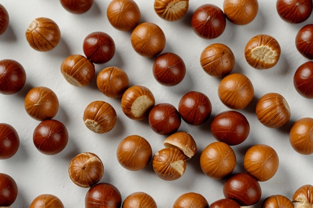 Photo top view of hazelnuts and peanuts with candies on white surface