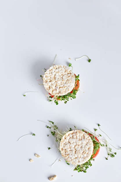 Top view Healthy burger with crispy rice bread vegetables tomato and microgreens