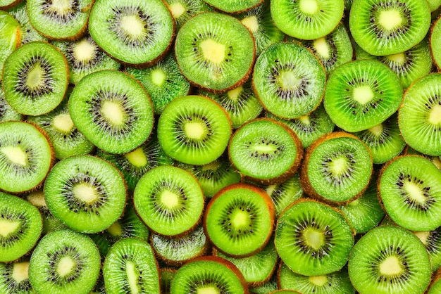 Top view of heap of sliced kiwi as textured background