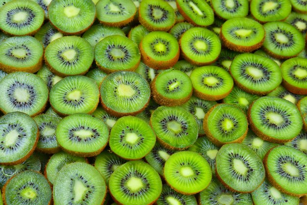 Top view of heap of sliced kiwi as textured background