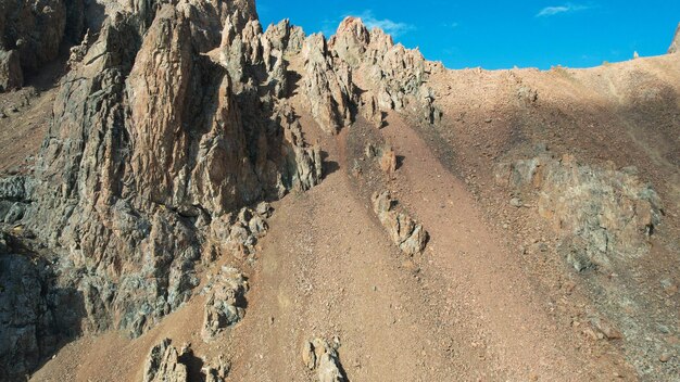 Top view of the high rocky mountains with trails. There is snow in places