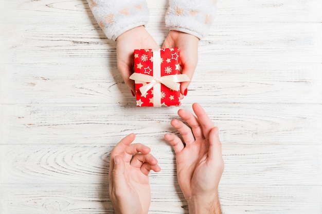 Top view of holding a gift in female and male hands 