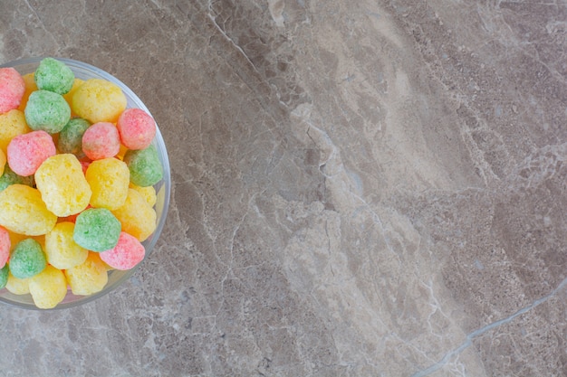 Top view of homemade colorful candies in bowl over grey.