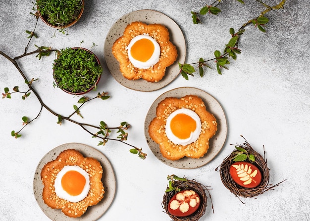 Top view of homemade sweet flower shaped cakes with apricot icing and chopped almond nuts