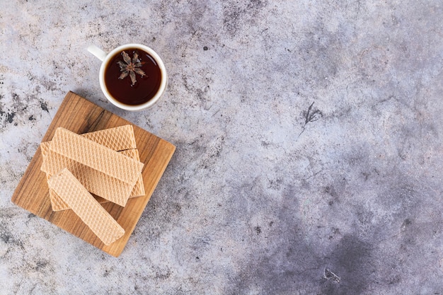 Top view of homemade wafers with fragrant tea on grey