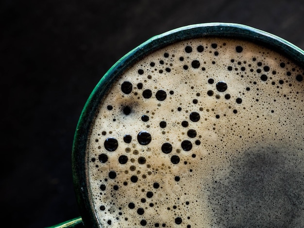 Top view hot coffee in green cup on wood background