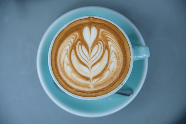 Top view of hot coffee latte in a blue cup