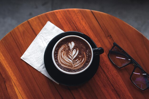 Top view of Hot coffee with latte art served on wooden table