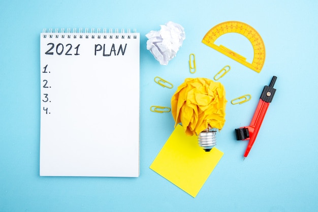 top view idea light bulb concept with crumpled paper and gem clips sticky notes plan written on notebook on table