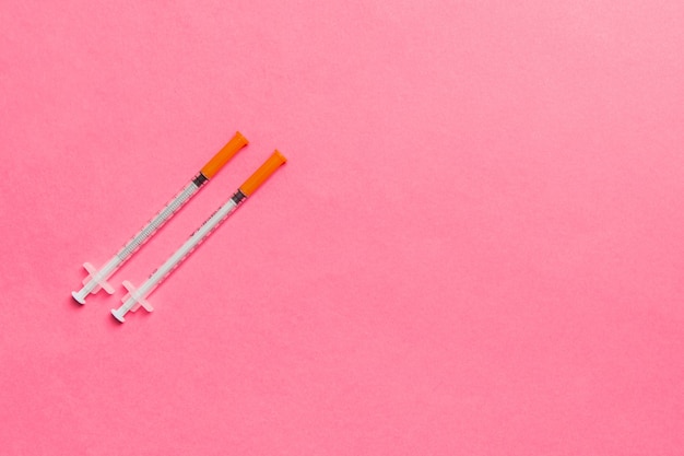 Top view of insulin syringes ready for injection on colorful surface