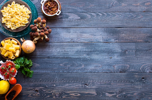 Top view of italian ingredients for spaghetti, over a wood background.