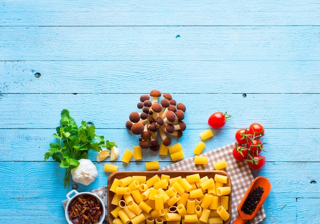 Top view of italian ingredients for spaghetti, over a wood background.