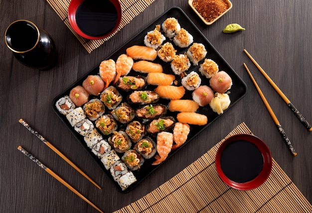 Top view Japanese food combo and crispy onions served in restaurant on black plate on wooden table