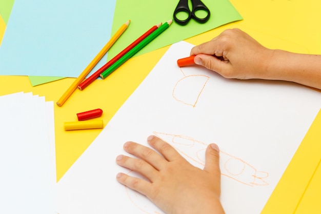 Top view of kids hands paiting with crayons Indoor activity