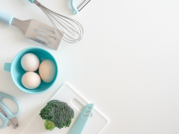 top view of kitchen room concept with kitchenware, egg and vegetables on white table background.