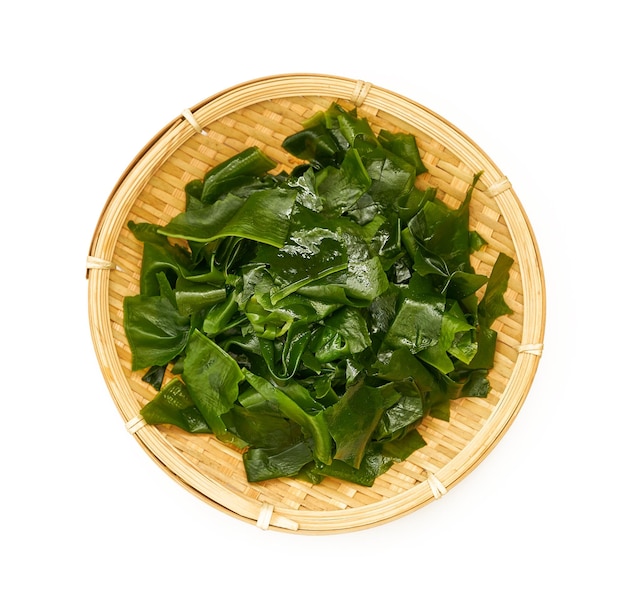 top view Laminaria or Kelp Seaweed in wood plate Isolated on White Background. fresh Laminaria