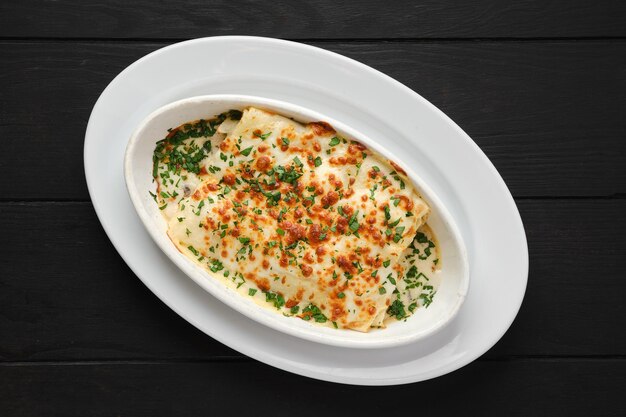 Top view of lasagna with cheese, chicken and vegetables on a plate