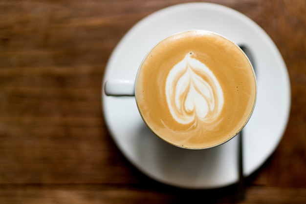 Top view latte art coffee on wooden. heart shape latte art foam. S