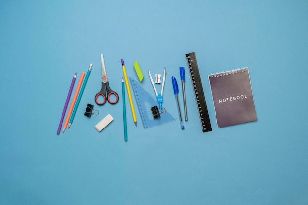 A top view layout of some different school supplies on pastel background