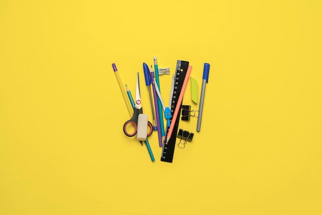 A top view layout of some different school supplies on pastel background