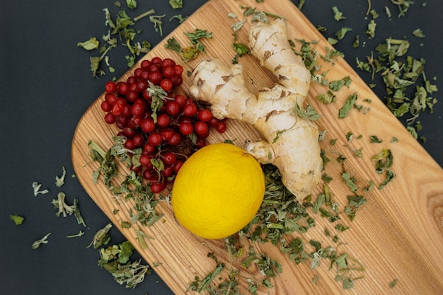 Top view. Lemon, mint, ginger and viburnum on a wooden background.