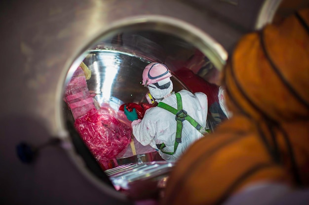 Top view male climbs up the stairs into the tank stainless chemical area confined space safety