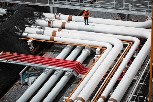 Top view male worker inspection at steel long pipes and pipe elbow in station oil factory during refinery valve of visual check record pipeline oil