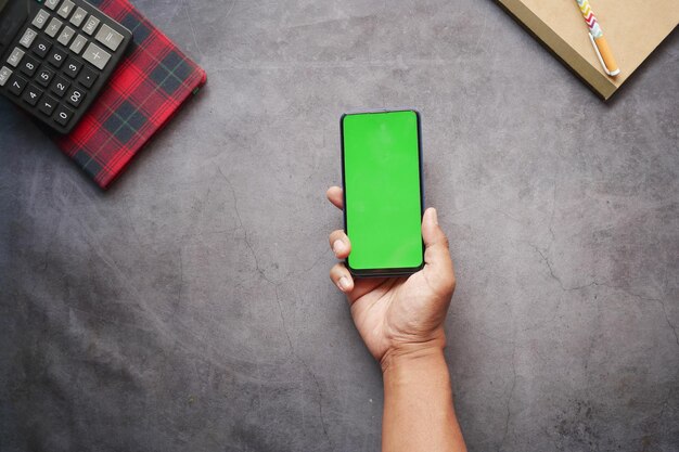 Top view of man hand using smart phone on office desk