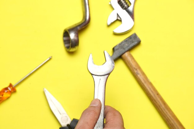 Photo top view of man's hand grabbing a tool. repair or maintenance concept. flat lay flat design