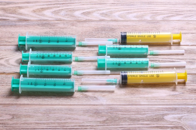 Top view of many syringes prepared for injection at wooden background Treatment concept with copy space