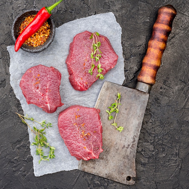 Top view of meat on cleaver with spices and chili