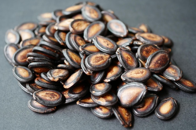 Top view of melon seeds in a bowl on black background