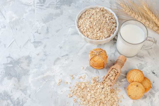 top view milk bottle and milk glass cookies oats bowl wheat spikes on grey background copy place