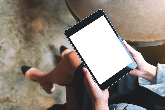 Top view mockup image of a woman holding black tablet with white blank screen