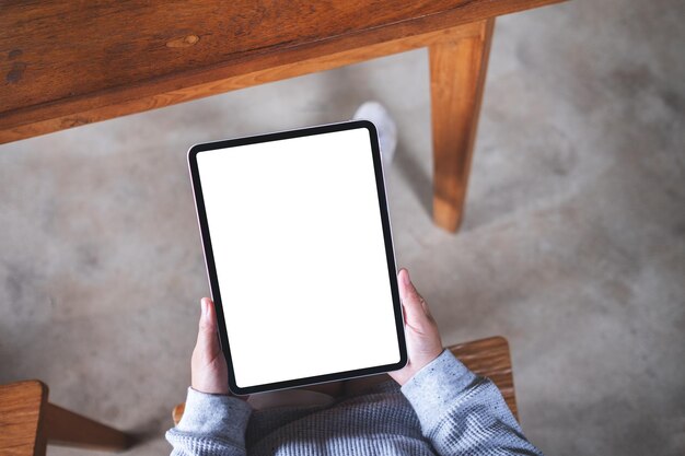 Top view mockup image of a woman holding digital tablet with blank white desktop screen