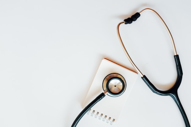 Top view of modern, sterile doctors office desk  with stethoscope on white background.