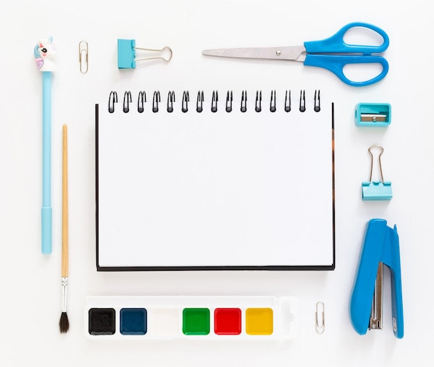 top view of modern white blue office desktop with school supplies and stationery