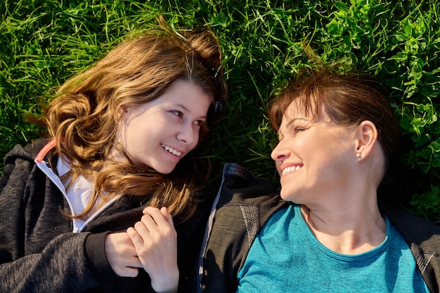 Top view of mother and daughter lying together on grass