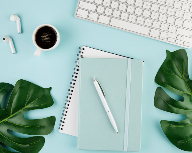 Top view of notebook on desk with coffee and leaves