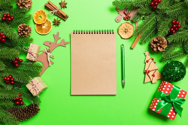 Top view notebook on green  made Christmas decorations.   time 